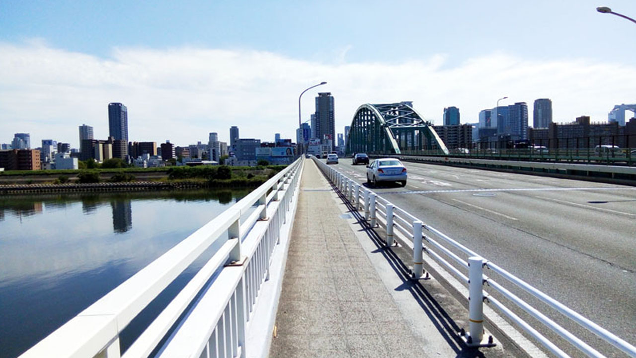 Crossing the wide Yodo River on bridge heading into central Osaka