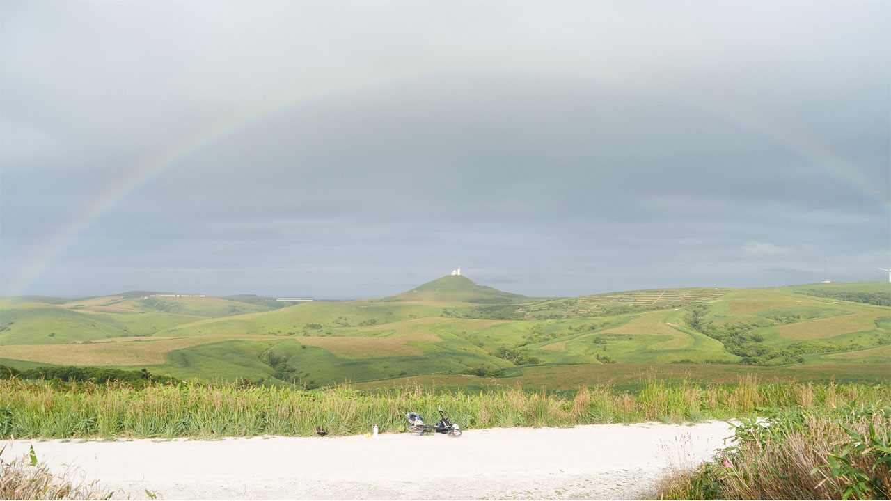 Scenic coastal road in Hokkaido with mountains in background - typical cycling route scenery