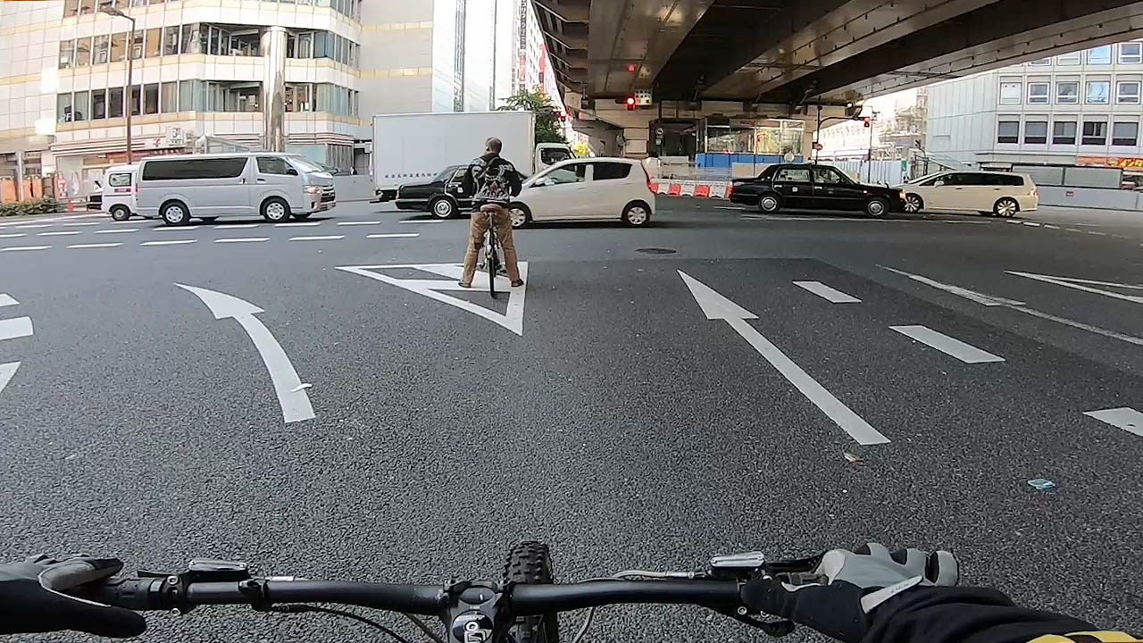 Cyclist at a Japanese intersection with traffic lights and two-stage right turn signage