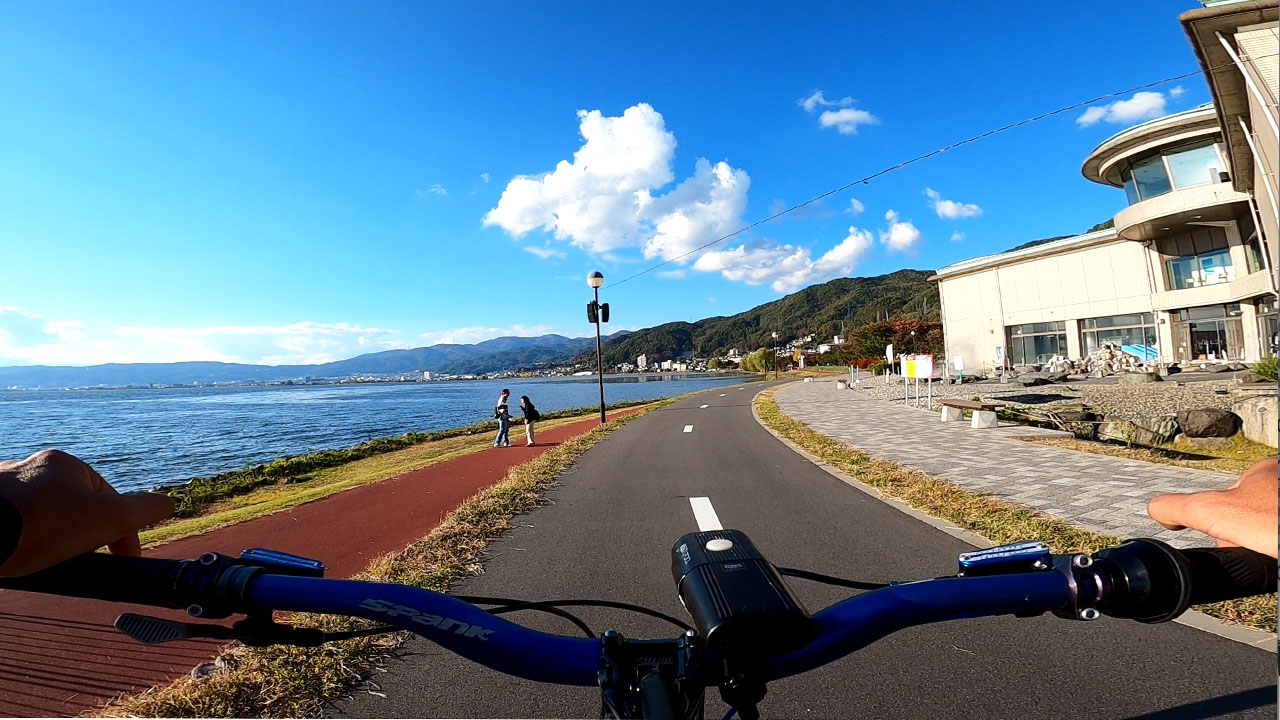 Suwa Lake cycling path - dedicated bicycle lane along the lakeshore with mountains in background
